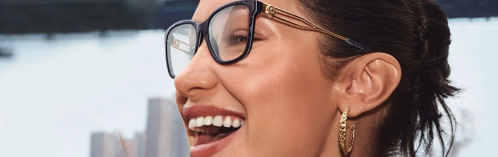 modelo con vestimenta de alta costura usando anteojos Michael Kors de silueta ojo de gato con sutiles detalles dorados